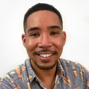 Headshot of De'Shan Perry in a button-up hawaiian shirt