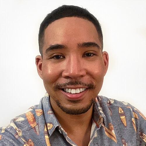 Headshot of De'Shan Perry in a button-up hawaiian shirt